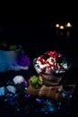 Selective focus of vanilla ice cream with multiple fruits in a cute glass jar on a wooden board