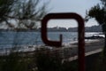 Selective focus view of the beach and sea seen from behind a pole sign Royalty Free Stock Photo