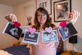 Pregnant woman holds echography scans