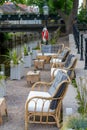 Selective focus view of an idyllic waterfront patio of a restaurant with lounge chairs and small tables