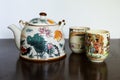 Selective focus view of pretty ceramic Japanese teapot with flowers and fish pattern and two cups Royalty Free Stock Photo