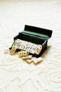 Selective focus view of vintage mother of pearl miniature dominoes spilling from their case Royalty Free Stock Photo