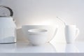 Selective focus view of white ceramic bowls, coffee cup with metal straw and kettle