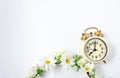Selective focus vintage alarm clock  with beautiful bouquet flowers  on white background. Love anniversary, dating and present Royalty Free Stock Photo