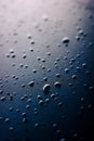 Selective focus on water drops on slippy surface of black synthetic fabric with bright light from background