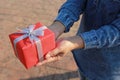 Selective focus of Woman hand holding gift box with red ribbon for Christmas and New Year`s Day or Greeting season Royalty Free Stock Photo
