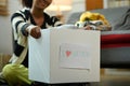 Selective focus on woman hands holding box of clothes with donate label. Charity, donation and reuse recycle concept Royalty Free Stock Photo