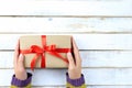 Selective focus of Woman hands holding gift box with red ribbon Royalty Free Stock Photo