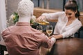 selective focus of woman pouring wine into glass while sitting at table with layman doll unrequited Royalty Free Stock Photo