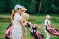 selective focus of women in caps with golf gear walking on green lawn Royalty Free Stock Photo