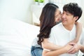 Two young asian couple girl piggyback man from back on bed,romantic asia people in love hugging while sitting in bed,valentine day Royalty Free Stock Photo