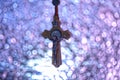 wood crucifix hang up in blue ray and violet bokeh for background and inspiration