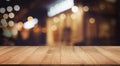 Selective focus.Wood table top with blur light bokeh in dark night cafe,restaurant background Royalty Free Stock Photo