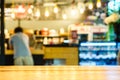 Selective focus of wooden table in front of decorative indoor string lights.