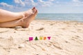 Selective focus on the word Happy on the background of female feet and the sea. Royalty Free Stock Photo