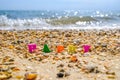 Selective focus on the word Happy from multicolored letters among sand and seashells on the seashore. In the background