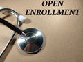 Selective focus.Word OPEN ENROLLMENT on wooden board with stethoscope.Medical concept.