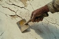 With selective focus, a worker uses a trowel to spread plaster over ceiling cracks for repair Royalty Free Stock Photo