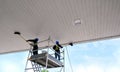 workers on scaffold are cleaning white ceiling of petrol station Royalty Free Stock Photo