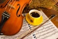 In selective focus of the yellow ceramic coffee cup put beside classic violin,vintage and art style