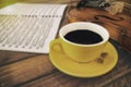 In selective focus of yellow ceramic coffee cup put beside violin ,in wooden timber board