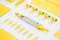 Selective focus of yellow paper clips, compasses and envelope on white background. Royalty Free Stock Photo
