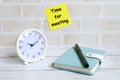 Selective focus of yellow sticky notes written with & x27;TIME FOR MEETING& x27; with notebook,pen and table clock Royalty Free Stock Photo