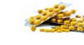 Selective focus on yellow tablets pill on blurred background of blister pack of round yellow pills. Diclofenac medicine