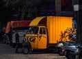 a yellow three wheeler mini truck in the night