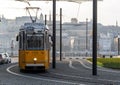 Selective focus of a yellow tram with the cityscape of Budapest in the background