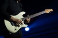 Selective focus on young Asian man guitarist`s hand playing electric guitar solo with full spectrum of light at concert Royalty Free Stock Photo