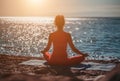 Selective focus. Young beautiful caucasian woman in a red suit practicing yoga on the beach at sunrise near the sea. Yoga. Healthy