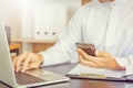 Selective focus of Young business Arab Middle East muslim man using mobile smart phone with laptop in office