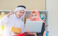 Selective focus of Young business arab middle eastern muslim working using computer and smiling while standing in workshop