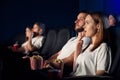 Caucasian couple watching horror movie in movie theater.