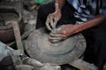 Selective focused on the dirty wrinkled skin hands of old man molding the clay work on the spinning wheel for making the jar with Royalty Free Stock Photo