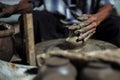 Selective focused on the dirty wrinkled skin hands of old man molding the clay work on the spinning wheel for making the jar with Royalty Free Stock Photo