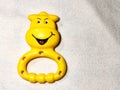 Selective focused yellow smiling baby toy placed on a white towel.