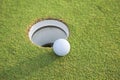 Selective foucs close up of golf ball near hole on green Royalty Free Stock Photo