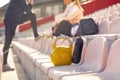 Selective image with focus on sport equipment, kettlebell and plastic bottle for water, with people behind, sitting on stadium Royalty Free Stock Photo