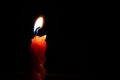 Selective of a lit red candle in the darkness Royalty Free Stock Photo