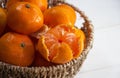 In selective of Peeled Orange put in woven basket ,beside group of blurred oranges