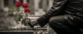 selective red color on a red rose. sad soldier placing flowers on a tombstone. Veterans Day, Memorial Day. Royalty Free Stock Photo