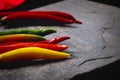 Selective shot of different types of Chili peppers on a stone plate Royalty Free Stock Photo