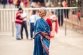 Selective shot of an old Indian female with a blue sari standing in the street, Visakhapatnam,India