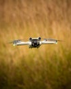 Selective vertical shot of a quadcopter flying over a blurry field