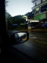 Selectively focused image of a car mirror in a rainy day with blurred background Royalty Free Stock Photo