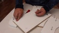 Self-assembly of furniture. A man installs cams in the wooden elements of a tabletop shelf