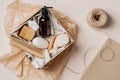 Self care beauty box preparation top view. Gift box with shampoo bottle, hair comb, cream, soap, moisturizer Royalty Free Stock Photo