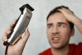 Self-care in the conditions of global quarantine and closed hairdressers and beauty salons. Handsome man cutting his own hair with Royalty Free Stock Photo